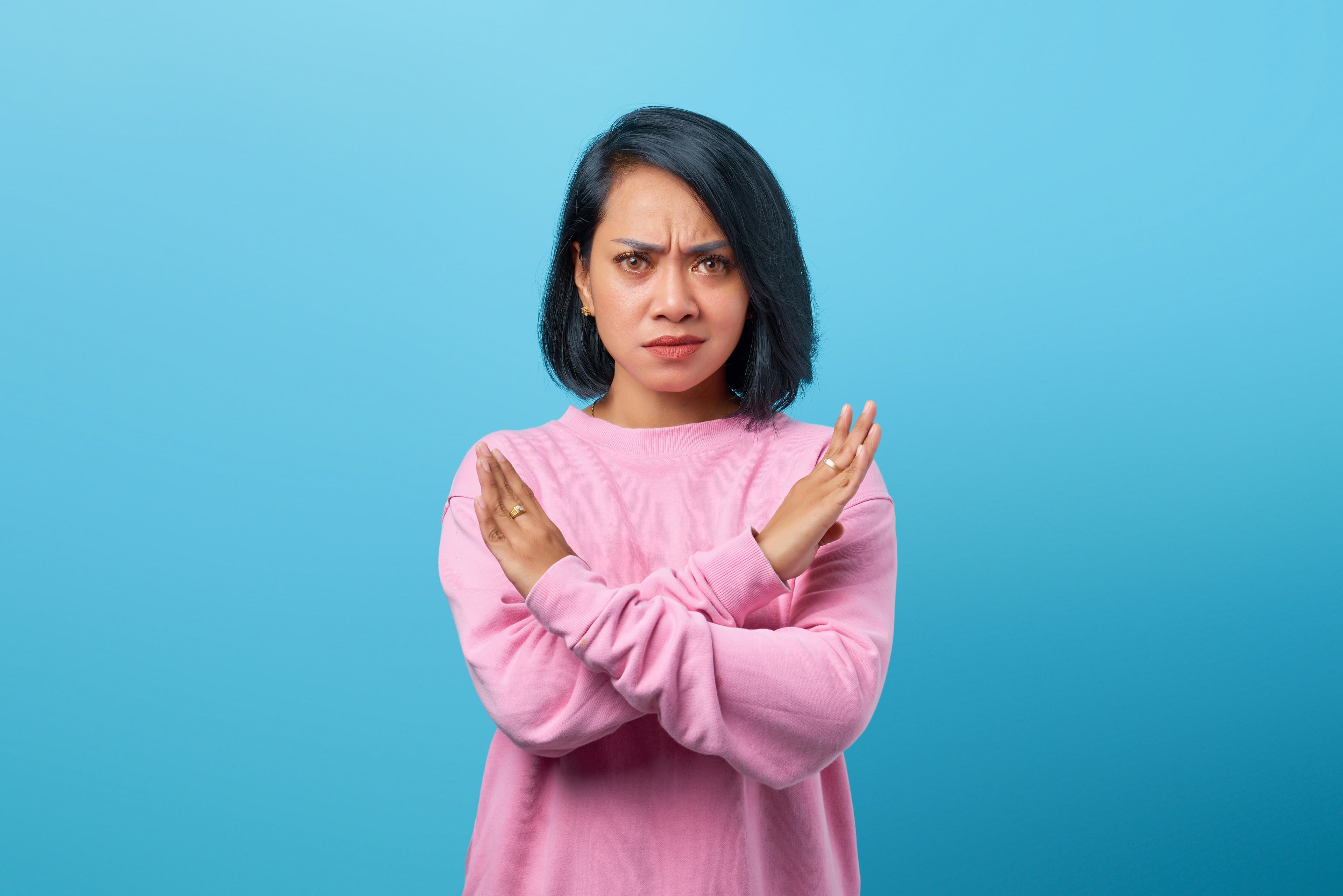A woman crossing her arms in a firm no.