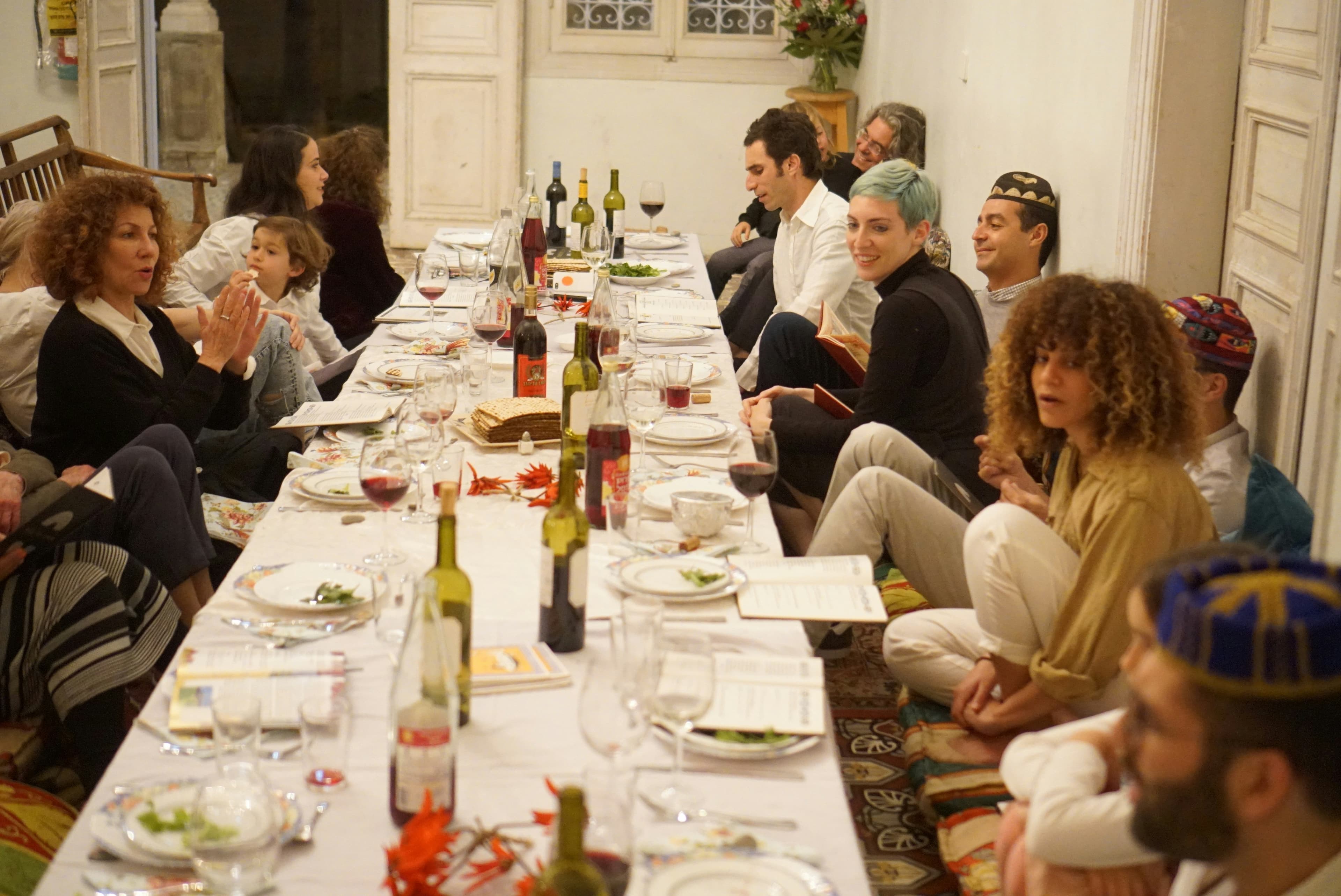 A large family gathered for a holiday meal at a long table.
